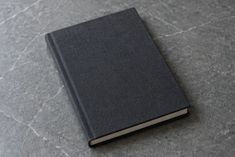 A closed charcoal notebook on a quiet table